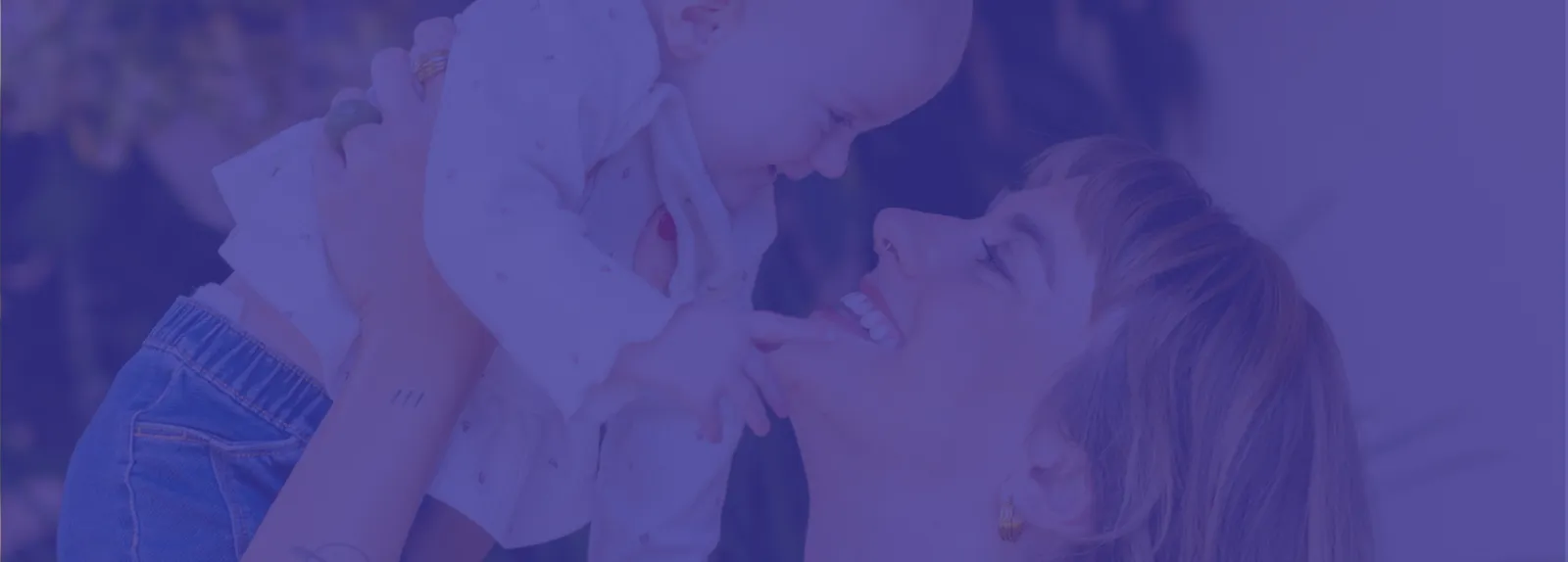 Mother lifting her smiling baby into the air